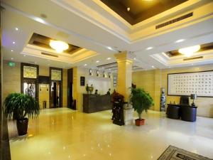 a lobby with potted plants in a building at GreenTree Eastern Yantai Development Zone Zhujiang Road Hotel in Yantai
