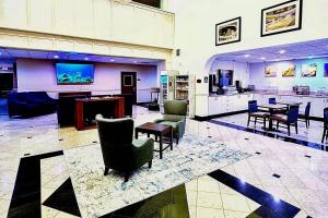 a large room with chairs and tables and a kitchen at Comfort Suites Westchase Houston Energy Corridor in Houston