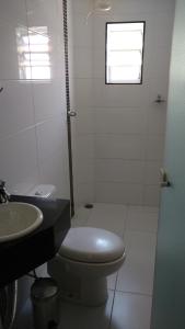 biała łazienka z toaletą i umywalką w obiekcie Lider Hotel w mieście São Bernardo do Campo