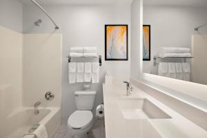 a white bathroom with a sink and a toilet at MainStay Suites Cincinnati Blue Ash in Blue Ash