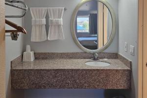 a bathroom with a sink and a mirror at Rodeway Inn & Suites Thousand Palms - Rancho Mirage in Thousand Palms +38 photos