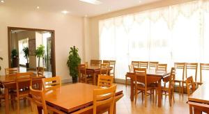 XiazhaにあるGreenTree Inn Zhongshan Nanlang Metro Station Branchの木製のテーブルと椅子のあるダイニングルーム