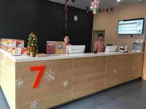 two men sitting at a counter in a store at 7 Days Premium·Shihezi Passenger Terminal in Shihezi