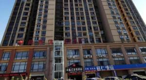 a tall building with a sign on top of it at Thank Inn Hotel Anhui Fuyang Funan County Yunhe Dong Road in Funan