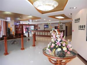 hol ze szklanym stołem i kwiatami w obiekcie GreenTree Inn Taicang Baolong Square Hotel w mieście Taicang