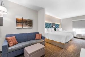 a hotel room with a bed and a couch at Brentwood Suites Nashville, an Ascend Collection Hotel in Brentwood +55 photos