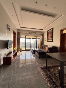 Una gran sala de estar con un sofá y un televisor. en Modern spacious 2 Bedroom apartment in Kigali, en Kigali