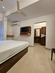 a bedroom with a bed and a flat screen tv at Golden Keys in Bengaluru +24 photos