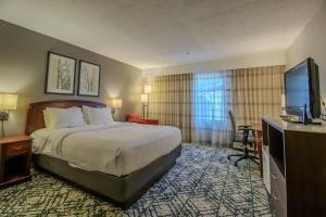 a hotel room with a bed and a flat screen tv at Country Inn & Suites by Radisson, Convention Center in Altoona +178 photos