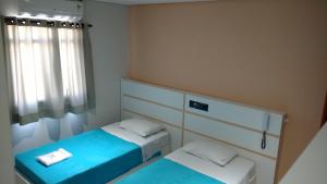 mały pokój z 2 łóżkami i oknem w obiekcie Lider Hotel w mieście São Bernardo do Campo