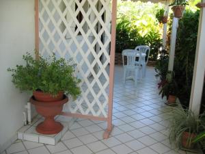 un patio con una valla blanca y una mesa con sillas en Meridienne Creole, en Sainte-Anne