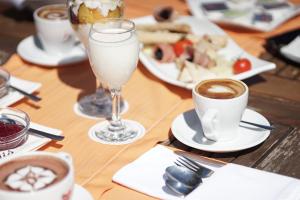 a table with plates of food and a glass of coffee at Valis Resort Hotel in Volos