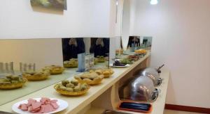 a buffet line with dishes of food and a mirror at GreenTree Inn Heze Mudan Road Bus Terminal Station Express Hotel in Heze