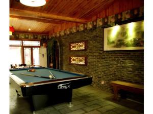 una camera con tavolo da biliardo e muro di mattoni di Parkside Hostel a Guilin