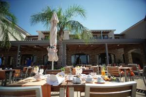 a restaurant with tables and chairs and an umbrella at Valis Resort Hotel in Volos