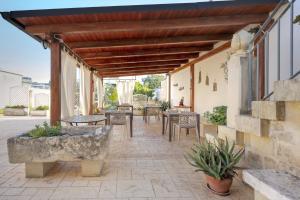 a patio with tables and chairs on a building at Dimora di Marco Exclusive Art Rooms in Melendugno