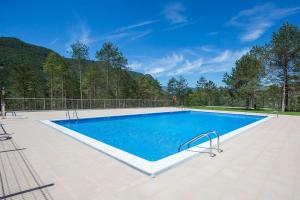 a large swimming pool with blue water in a yard at Alberg La Sala in La Pobla de Lillet