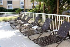 a row of lawn chairs in front of a fence at Chart House Suites and Marina in Clearwater Beach