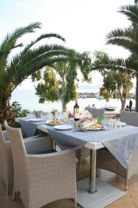 a table with a plate of food and a bottle of wine at Valis Resort Hotel in Volos