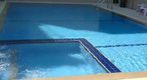 a large pool with blue water in a building at Hua Hin Avenue Hotel in Hua Hin