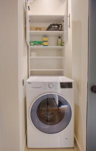 Luxury and stylish apartment in the heart of the city في صوفيا: غسالة ومجفف في غرفة صغيرة