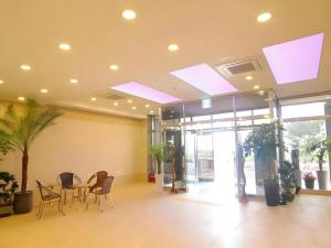 a lobby with a table and chairs in a building at Sea View Hotel in Jeju