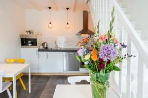 een vaas met bloemen op een tafel in een keuken bij Bij Jans in Hilvarenbeek