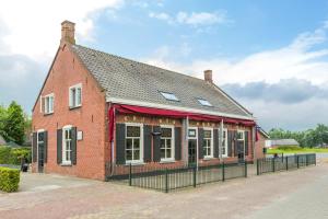 a red brick building with a black fence around it at Bij Jans in Hilvarenbeek