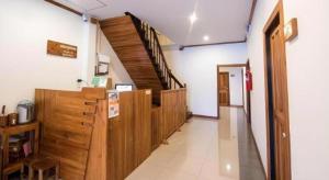 un corridoio con armadi in legno e scale in un edificio di Thongphaphum Place a Thong Pha Phum