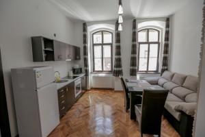 a kitchen and living room with a couch and a table at Poarta Schei Residence in Braşov
