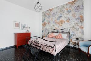a bedroom with a bed with a floral wall at Ca' Montello Apartment in La Spezia
