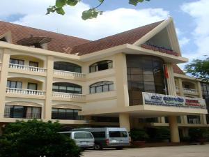 a building with a van parked in front of it at Cao Nguyen Hotel in Buon Ma Thuot