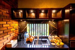 - une cuisine avec un évier et un mur en briques dans l'établissement Cinnamon Cottage Near Colombo Intl Airport, à Madampella Ihala 11 autres photos