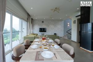 イガットプリにあるStayVista at Amara Palmsのダイニングルーム(テーブル、皿、ワイングラス付)