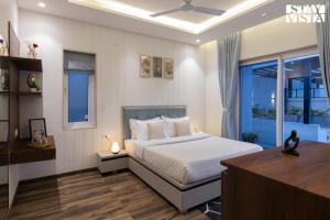 イガットプリにあるStayVista at Amara Palmsのベッドと窓のある寝室