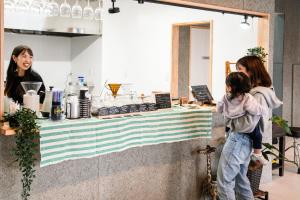 a woman and a child standing in front of a counter at 富士Base御殿場 3 minutes walk from Station in Gotemba