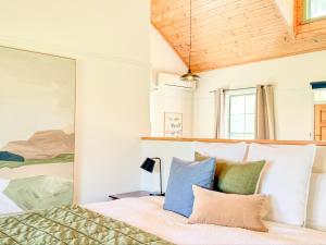 Schlafzimmer mit einem Bett mit blauen und grünen Kissen in der Unterkunft Clonmara Country House and Cottages in Port Fairy