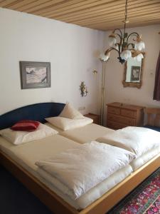 a bedroom with two beds and a chandelier at s'Landhaus in Sankt Anton am Arlberg