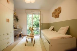 a bedroom with a bed and a desk and a window at L'ombelle - Studio vert d'eau avec petit extérieur in Darnétal