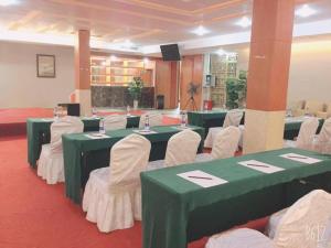 una sala de conferencias con mesas y sillas verdes y blancas en Dork Jumpa Hotel, en Vientiane