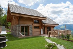 une cabane en rondins avec une terrasse et des chaises dans la cour dans l'établissement Les chalets perchés, à Muhlbach-sur-Munster