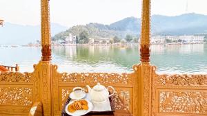 una mesa con un plato de comida y un juego de té en un barco en Houseboat New Golden Fleece, en Srinagar