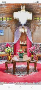 Habitación con mesa con flores y lámpara de araña. en Houseboat New Golden Fleece, en Srinagar 1 foto más