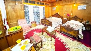 Un dormitorio con dos camas y una mesa y sillas. en Houseboat New Golden Fleece, en Srinagar