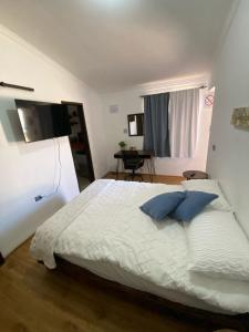 a bedroom with a bed with two blue pillows on it at Departamento en San Quintín BC in San Quintín