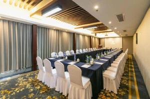 una sala de conferencias con una mesa larga con sillas blancas en SSAW Boutique Hotel Shaoxing Ancient Town, en Shaoxing