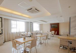 a dining room with tables and chairs and windows at City Comfort Inn Nanning Normal University Changgang Road Metro Station in Nanning