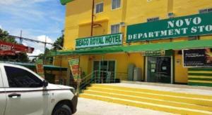 a white car parked in front of a yellow building at Meaco Royal Hotel- ILagan in Ilagan