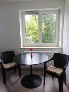 a table and two chairs in a room with a window at Allgäu Space in Marktoberdorf