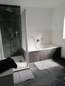 a bathroom with a shower with a tub and a sink at Allgäu Space in Marktoberdorf